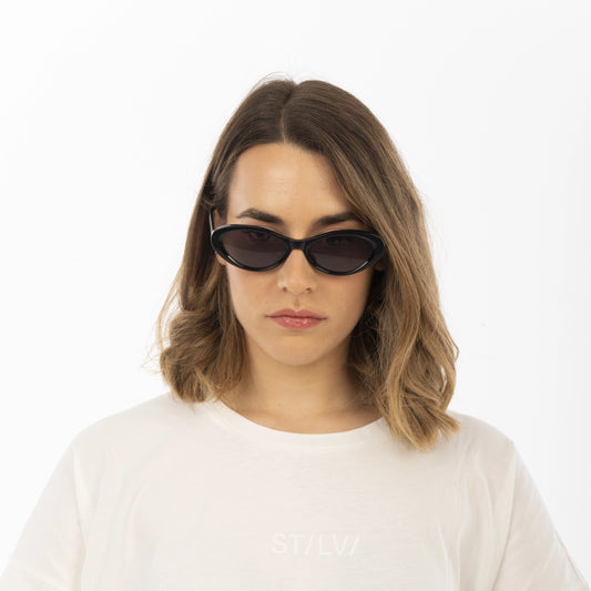 Woman wearing dark sunglasses on a white background