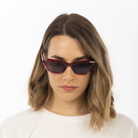 Woman wearing red sunglasses on a white background