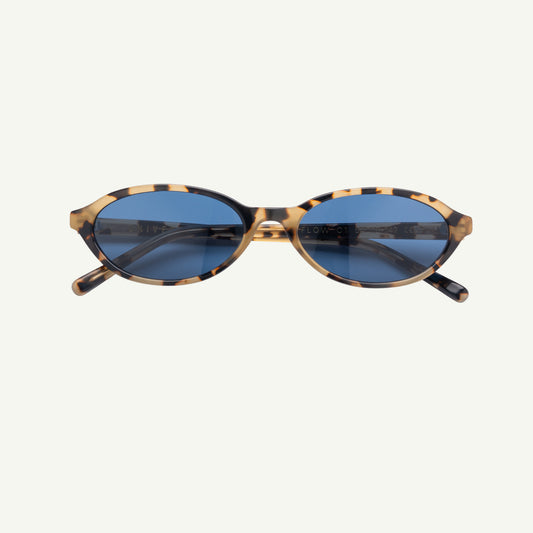Sunglasses with tortoiseshell frame and blue lenses on a white background