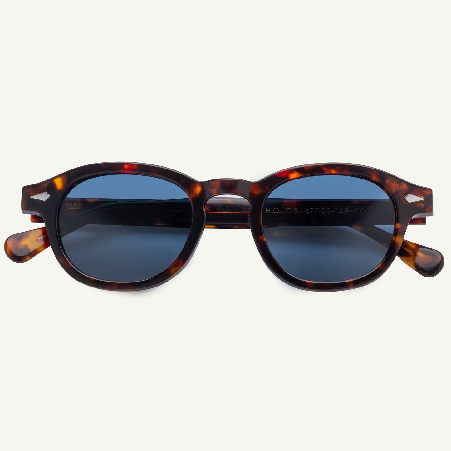 Sunglasses with tortoiseshell frame and blue lenses on a white background