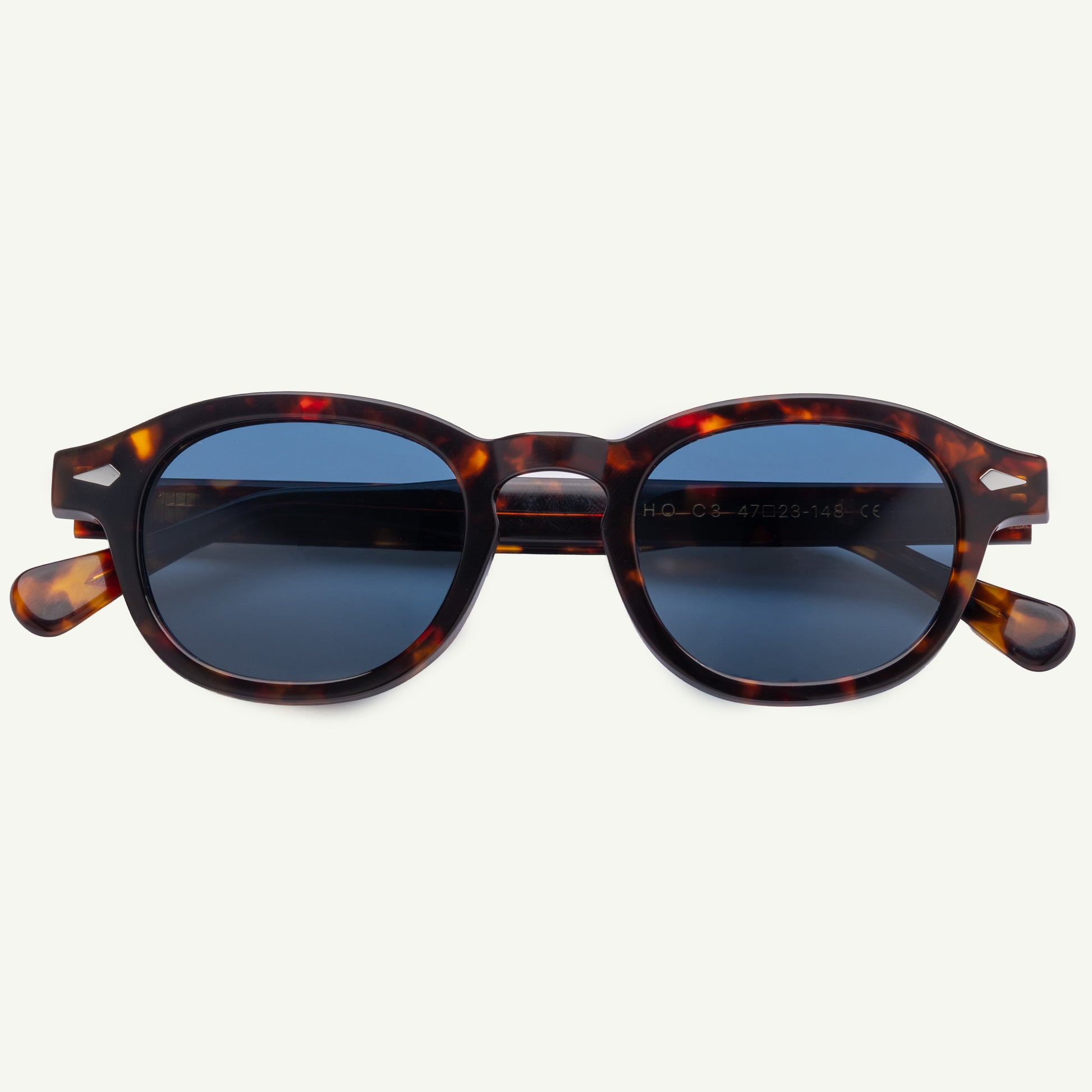 Sunglasses with tortoiseshell frame and blue lenses on a white background